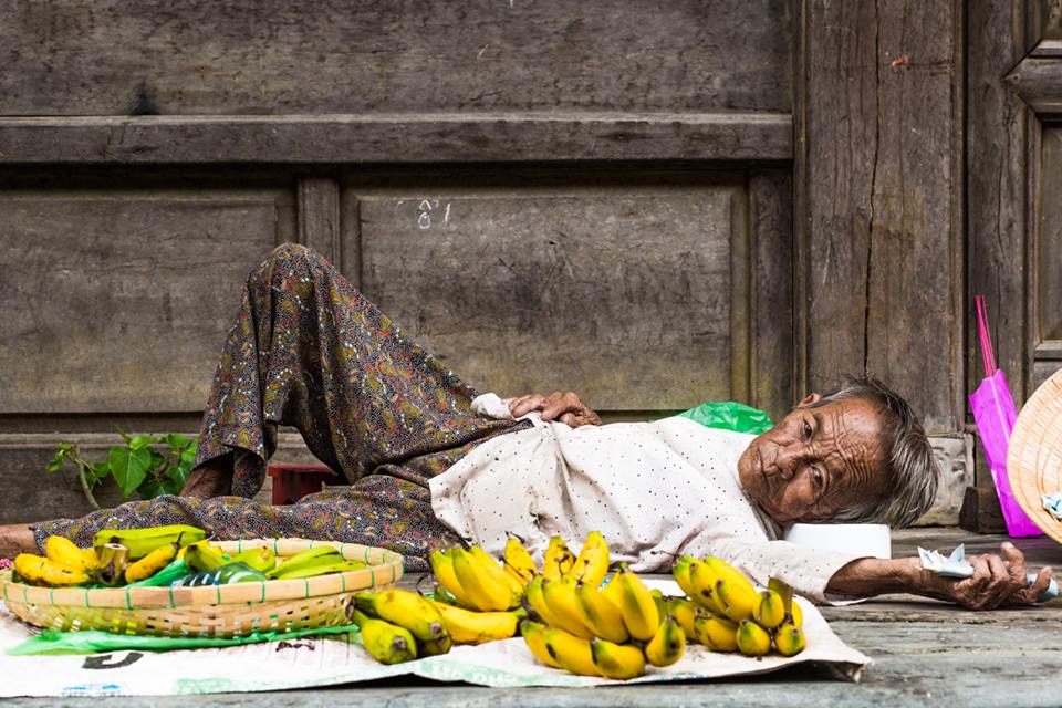 85 let, stále pracující, stále prodávající banány na chodníku Hoi An